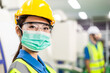 © winnievinzence - Portrait of Asian worker woman in medical face mask looking at camera in industrial factory. new normal working during coronavirus. healthcare lifestyle for industry people. copy space