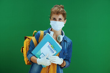 Wall Mural - young learner woman in yellow shirt against green background