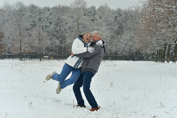 Poster - Happy senior couple hugging at snowy winter park