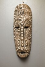 Close Up View Of African Wall Mask On Gray Wall Background Isolated. Interior Concept. 