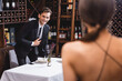 © LIGHTFIELD STUDIOS - Selective focus of man in formal wear looking at girlfriend during dating in restaurant