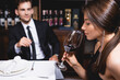 © LIGHTFIELD STUDIOS - Selective focus of young woman holding glass of wine near boyfriend in restaurant