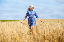Young Happy Blonde In A Blue Dress Posing In A Wheat Field