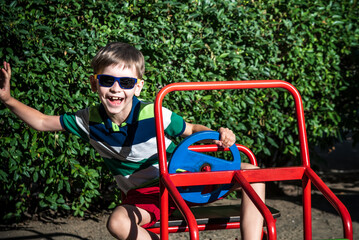 Wall Mural - Little boy driving big toy car and having fun, outdoors