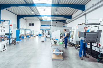 Workers working on the factory floor in well lit hall