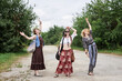 © Natalia - Three hippie women, wearing boho style clothes,, walking on dirt road in countryside, dancing, relaxing, having fun. Friends, traveling together in summer. Freedom and happiness concept.