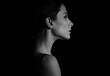 © nastia1983 - Beautiful woman with elegant healthy neck, nude back and shoulder on black background with empty copy space. Closeup profile view portrait. Art.Expression