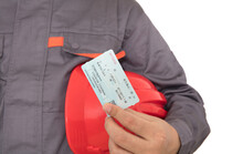 A Migrant Worker With A Red Safety Helmet In His Arm And A Train Ticket For Returning Home During The Spring Festival In The Other Hand