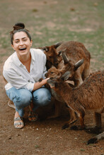 Woman At The Reserve In Australia Playing And Feeding Kangaroos