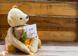 i am sorry message card handwriting with teddy bear holding gift box decoration postcard style on background wooden