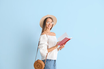 Sticker - Beautiful young woman with book on color background