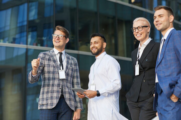 Wall Mural - Successful business people looking away and smiling while standing in the city