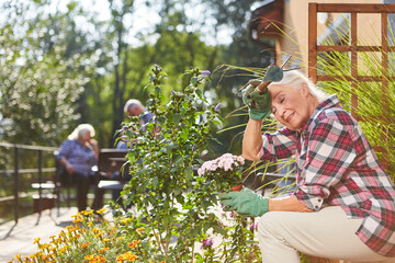 Erschöpfte Seniorin mit Blumen auf Terrasse