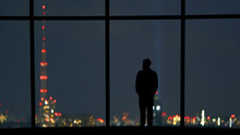 The Male Standing Near The Panoramic Window Against The Night City