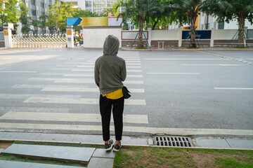 Lonely girl with hooded clothe in the city. Alone girl in danger concept