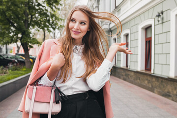 cute attractive stylish smiling woman walking city street in pink coat spring fashion trend holding 