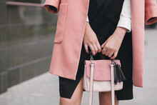 close-up hands of woman walking city street in pink coat spring fashion trend holding purse, elegant style, accessories details