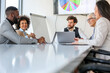 © Sanja - A group of business partners sits in a conference room and arranges new jobs and projects for corporation