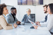 © Sanja - Group of business partners sit in a conference room, employees suggest new ideas in making a profit