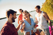© Zoran Zeremski - Group of young friends standing of a pier having fun and enjoying a summer day at the lake.