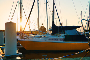 Poster - Sunset in the port. The concept of beautiful views over the sea. Moored boats and sailboats against the setting sun.