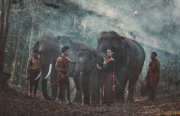 group of thai shepherds in the jungle with elephants. historic lifestyle moments from thailand cultu