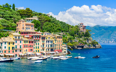 Portofino, Italy - Harbor town with colorful houses and yacht in little bay. Liguria, Genoa province, Italy. Italian fishing village with beautiful sea coast landscape in summer season.