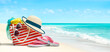 Summer beach bag and accessories - straw hat, flip flops and sunglasses on sandy beach and azure sea on background