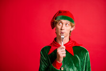 Photo Of Minded Elf Lick Fork Look Copyspace Think X-mas Christmas Dinner Isolated Over Red Bright Color Background