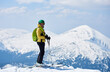 Sporty man enjoying skiing day and spectacularly view mountain landscape under blue sky Snow and winter activities, skitouring in mountains.