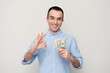 © Анастасия Семашко - Man with the cash shows sign okay with fingers, white background, copy space