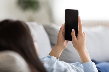 Wall Mural - Unrecognizable Female Lying On Couch At Home, Using Smartphone With Blank Black Screen