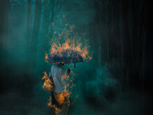 Digital Composite Image Of Woman Standing With Burning Umbrella At Night In Forest