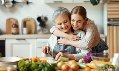 happy mother and daughter preparing healthy food at home.