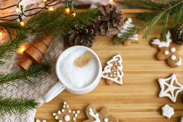 Wall Mural - Christmas  gingerbread cookies, coffee, pine cones, fir branches and warm lights on wooden table