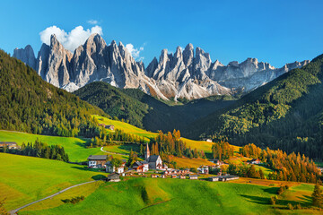 Wall Mural - Famous Alpe di Siusi - Seiser Alm with Sassolungo - Langkofel mountain group in background at sunset. Wooden chalets in Dolomites, Trentino Alto Adige region, South Tyrol, Italy