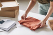 © AnnaStills - Close-up of woman packing new shirt she preparing parcels for delivery at the table