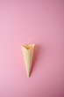 Empty waffle cone on a pink background close-up