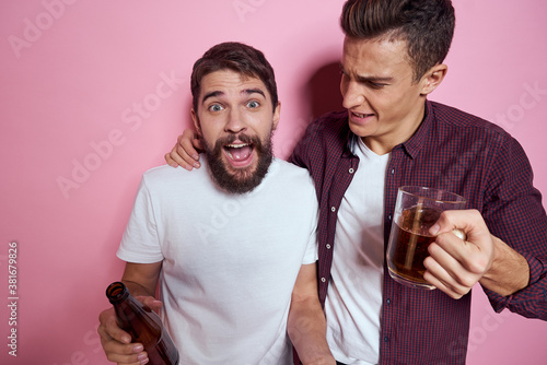 Cuadros en Lienzo Two men drink beer friendship drunk alcohol lifestyle pink background