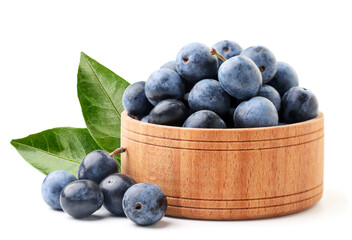 Blackthorn berries with green leaves in a wooden plate on a white background. Isolated