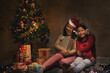 © sutlafk - Asian mother and daughter sitting with Present Gift Box near of Xmas Tree. Happy asia Mother with kid girl in Magic Night. Family merry christmas and newyear holiday concept.