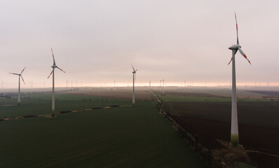  Windmills in countryside field with overcast sky