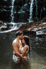 Poster - Cute young couple in a waterfall pool