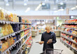 © lado2016 - Man shopping in supermarket, reading product information