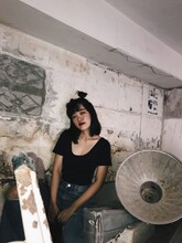 Grunge Fashion Portrait Of Woman Sitting Against Wall