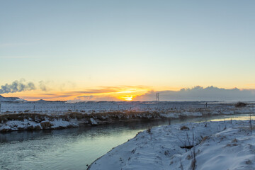 Wall Mural - River on the plain in Iceland. The banks are covered with snow. Winter landscape, open spaces.