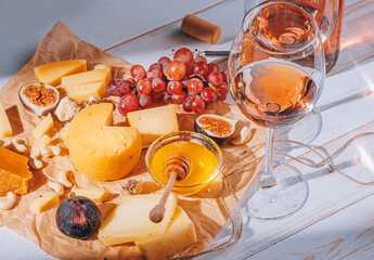 set of different types of cheese. romantic dinner for two. cheese fruit and two glasses of wine