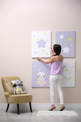 Poster - Decorator hanging picture on pink wall. Children's room interior design