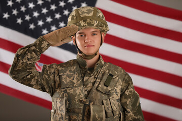 Male soldier saluting against American flag. Military service