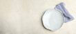 © New Africa - Empty plate and napkin on light table, top view